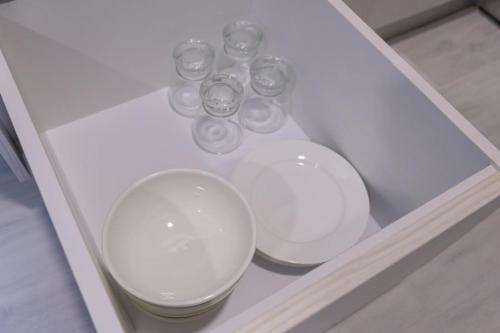 three glasses in a white cabinet with a shelf at JQ#11 City View Slide LoftBed 2R1B 5pax near Suria Mall, Gaya St, SICC in Kota Kinabalu