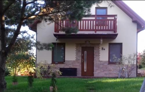 利茲巴克的住宿－Rajski Azyl，白色的房子,上面设有阳台