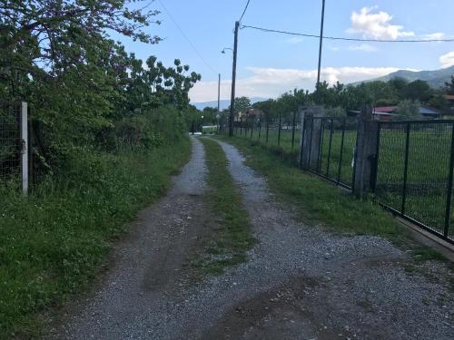 un camino de tierra con una valla al lado de un campo en PARADISE VILLA en Litóchoron