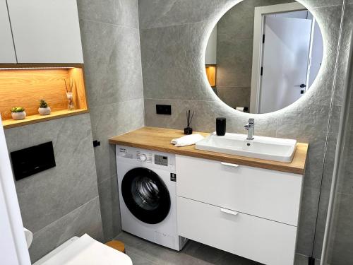 a bathroom with a washing machine and a sink at Apartament Aleksandra SPA Dziwnów in Dziwnów