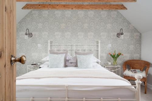 een slaapkamer met een wit bed en een stoel bij Beinn Cottage - Seasgair Lodges in Kincraig
