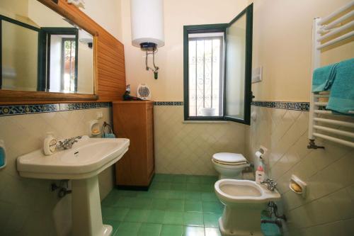 a bathroom with a sink and a toilet and a mirror at Il Gelsomino in Palermo