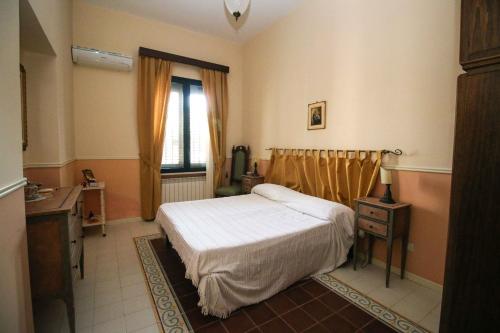 a bedroom with a bed and a desk and a window at Il Gelsomino in Palermo