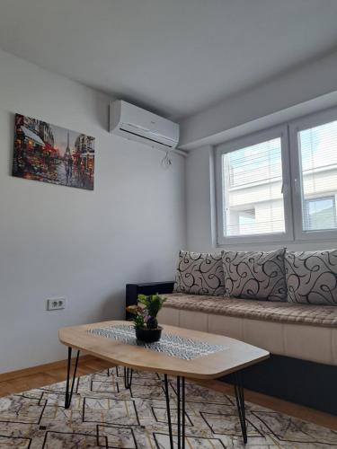 una sala de estar con una mesa y un sofá en The Romantic Place, en Skopje