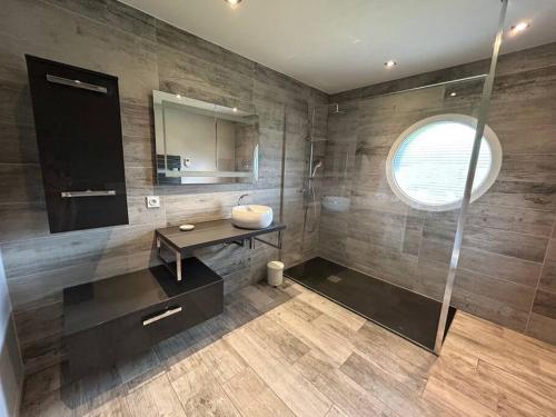 ein Bad mit einem Waschbecken und einer Glasdusche in der Unterkunft Villa 4 Saisons, avec piscine chauffée et jacuzzi in Gérardmer