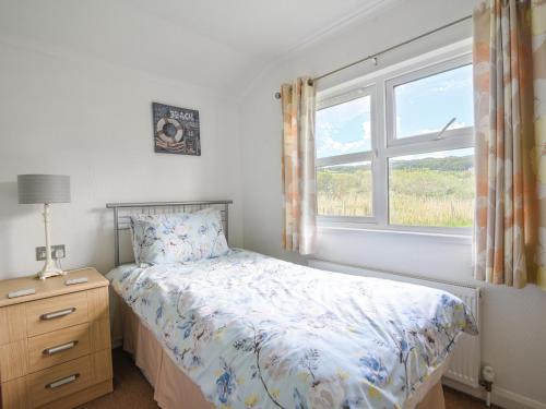 a bedroom with a bed and a window at The Hideaway in Bridport