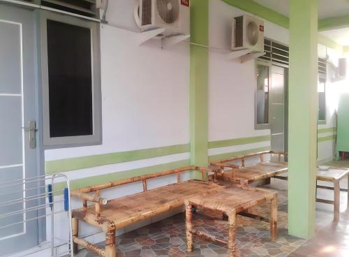 dois bancos numa sala com paredes verdes e brancas em Penginapan Asri Guest house 