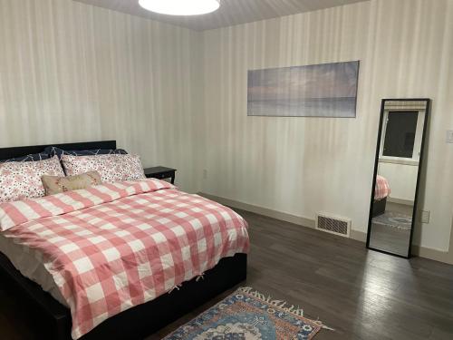 1 dormitorio con cama y espejo en Winter Madness Vibes en Sylvan Lake