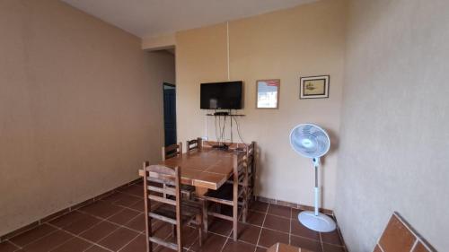 a room with a table and a fan in a room at Temporada no Paraíso in Ilha Comprida