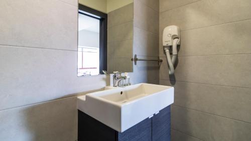 a bathroom with a white sink and a mirror at Abadia by LovelyStay in Porto