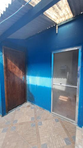 an empty room with a blue wall and a door at Temporada no Paraíso in Ilha Comprida
