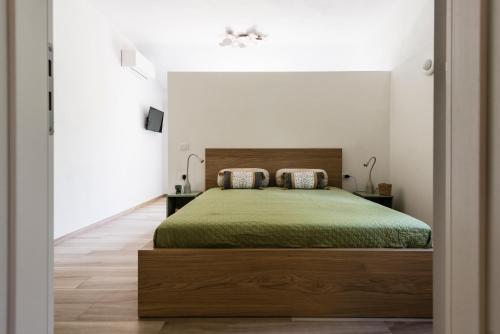 a bedroom with a green bed in a white room at Agriturismo La Mignola in Campiglia Marittima