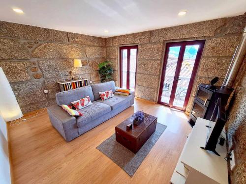 un soggiorno con un divano e un tavolo di Stone House Entre os Rios a Entre-os-Rios - Penafiel