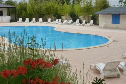 a swimming pool with lounge chairs and a bunch at Mobilhome dans parc résidentiel de loisirs in Saint-Cyr-en-Talmondais