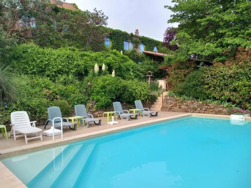 a swimming pool with chairs and tables next to it at Gite Les Volets Bleus du Segur in Le Ségur-Suech