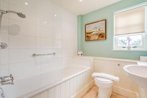 a bathroom with a tub and a toilet and a sink at Tiger Inn _ Minnie in Eastbourne