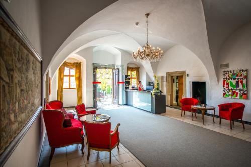 a living room with red chairs and a table at Hotel Resort Schloss Auerstedt in Auerstedt