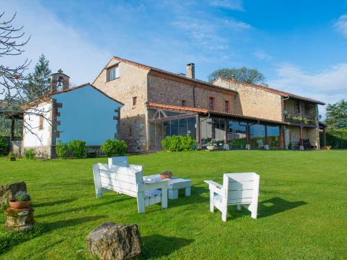 ein Haus mit zwei Stühlen und einem Tisch im Hof in der Unterkunft La Ermita de Deva in Deva