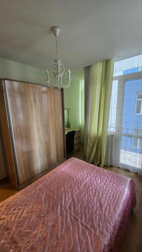 a bedroom with a large bed and a chandelier at Apartament in Batumi