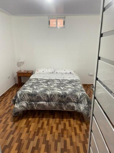 um quarto com uma cama e piso em madeira em Ekm Deptos em Apóstoles