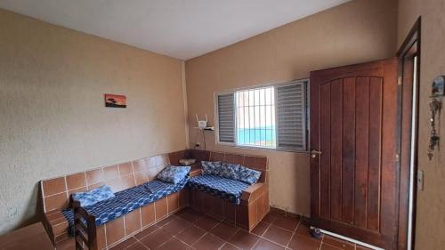 a room with two beds in the corner with a window at Temporada no Paraíso in Ilha Comprida