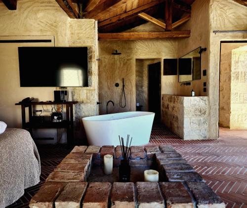 bagno con vasca, TV e letto di Amalen Suites Adults Only a Rethymno