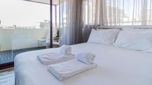 a bedroom with a white bed with towels on it at Abadia by LovelyStay in Porto