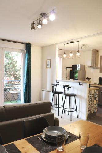 un salon et une cuisine avec un canapé et une table dans l'établissement Le Chapitre Spacieux - parking en résidence fermée, à Toulouse