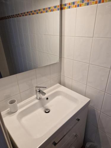 een badkamer met een witte wastafel en een spiegel bij Chambre in Sulniac