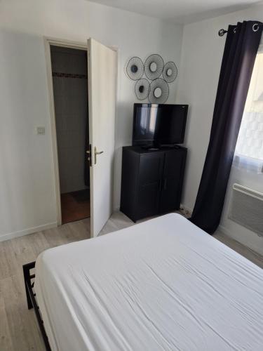 1 dormitorio con 1 cama y TV de pantalla plana en Chambre, en Sulniac