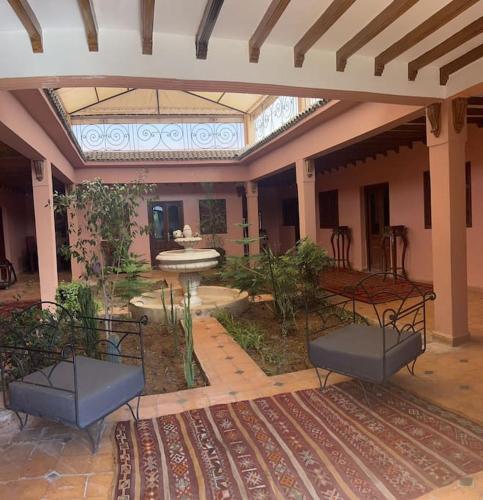 a courtyard with two chairs and a fountain in a building at dream farm in Marrakesh