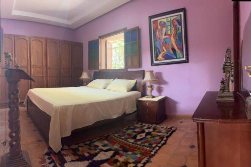 a bedroom with purple walls and a bed and a rug at dream farm in Marrakesh