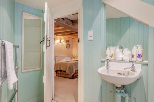 a bathroom with a sink and a room with a bed at Tiger Inn - Patience in Eastbourne