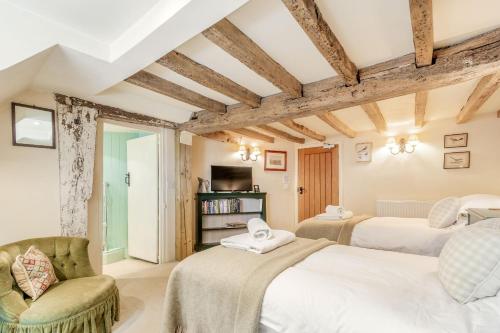 - une chambre avec deux lits et une chaise dans l'établissement Tiger Inn - Patience, à Eastbourne