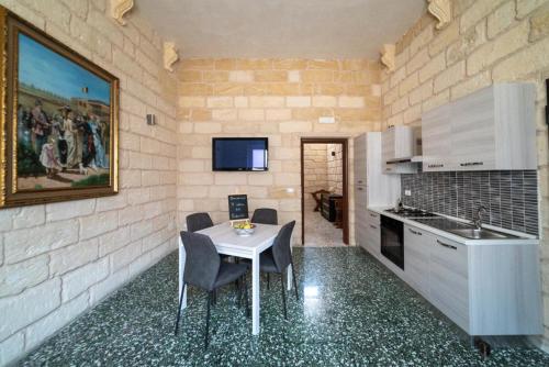 a kitchen with a table and chairs in a room at Il colore del Salento in Carpignano Salentino