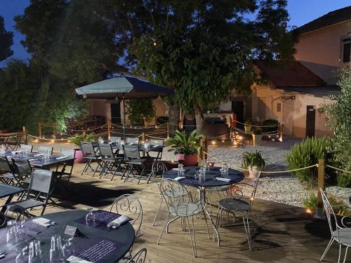 un grupo de mesas y sillas en un patio en Hôtel des Moulins, en Allauch