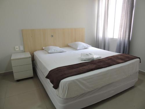 a bedroom with a large white bed with a wooden headboard at Hotel Ourinhos - Centro de São Paulo - Próximo 25 de Março e Brás - By Up Hotel in São Paulo