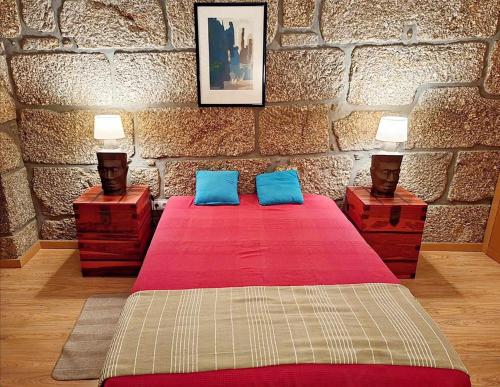 a bedroom with a red bed with two night stands at Stone House Entre os Rios in Entre -os- Rios
