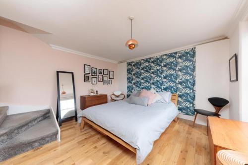 a bedroom with a large bed and a mirror at Bright & spacious modern 2 bedroom apartment in London