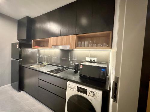 a kitchen with a washing machine and a microwave at Crystal Suites at Axon Residence near Pavilion in Kuala Lumpur