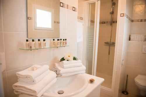 uma casa de banho com um lavatório, um chuveiro e toalhas em Oasis Les Jardins des Sables d'Olonne em Les Sables-dʼOlonne