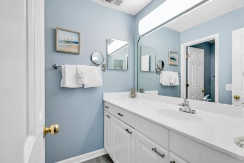 a bathroom with a white sink and a mirror at Stunning 2BR Condo at Waterway Village in Myrtle Beach