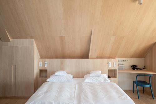 a bed in a room with a wooden ceiling at Miramonti Boutique Hotel in Avelengo