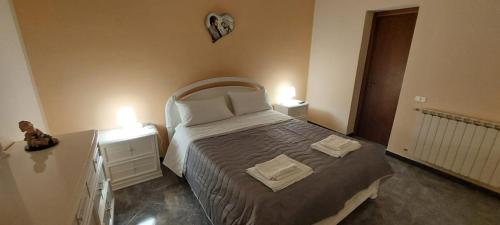 1 dormitorio con 1 cama grande y 2 mesitas de noche en La maison de Mary, en Zafferana Etnea