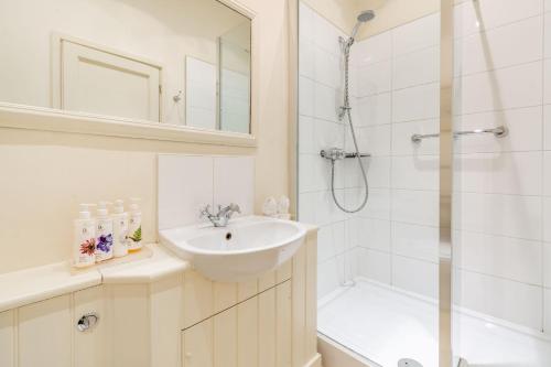 a white bathroom with a sink and a shower at Tiger Inn - Catherine in Eastbourne