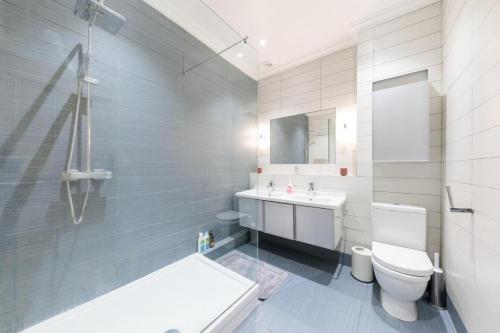 a bathroom with a white toilet and a sink at Bright & spacious modern 2 bedroom apartment in London