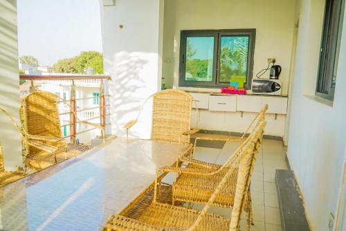 - Balcón con mesa y sillas de mimbre en MGM Apartments Gambia, en Kololi