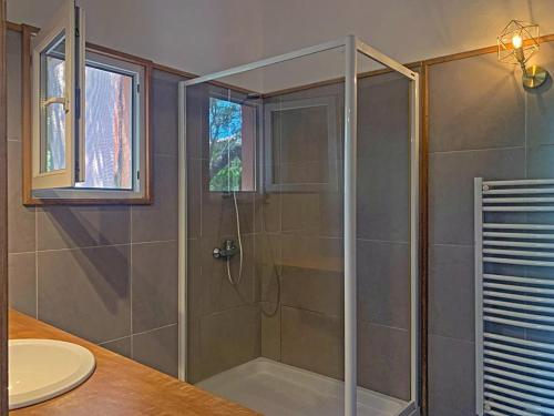 a shower with a glass door in a bathroom at Hôtel Maora Village in Bonifacio