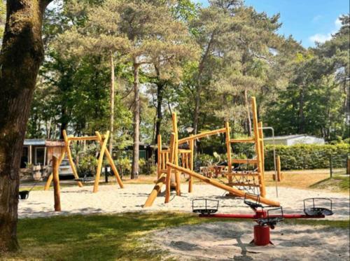 - un parc avec une aire de jeux et une balançoire dans l'établissement De Eekhoorn, à Zuidwolde