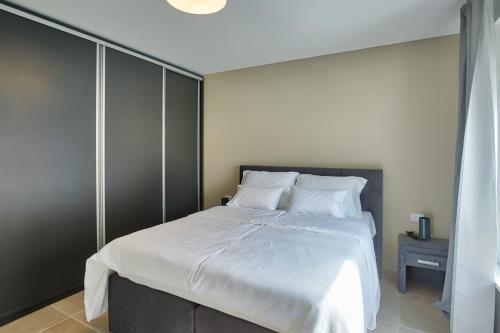 a bedroom with a large bed with white sheets at Villa Sponza in Medulin